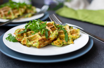 zucchini waffles with fresh arugula on white plate