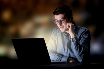 Young handsome businessman working late at night in the office