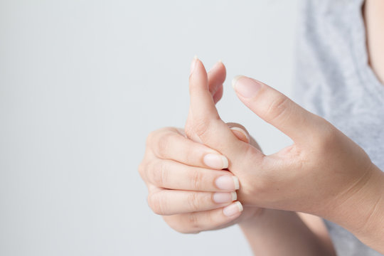 Young Woman Suffering From Pain In Hands And Massaging Her Painful Hands. Health Care And Medical Concept.