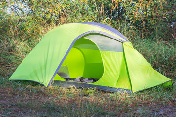 Green tent at a campsite in the forest