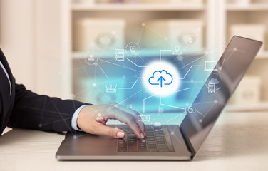 Business woman in homey environment using laptop with online storage and cloud technology concept