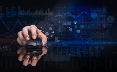 Hand using wireless mouse with financial concept on dark background