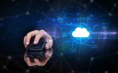 Hand using wireless mouse in a dark environment with cloud technology and online storage concept