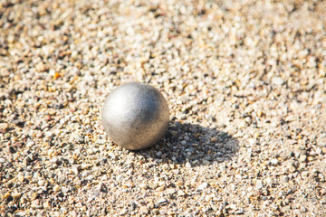 Close up of Bocce ball or Metallic petanque ball on Gravel