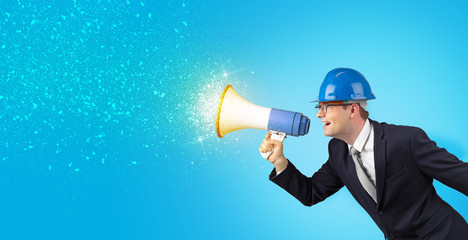 Fototapeta premium Young architect constructor yelling with megaphone and sparkling sounds