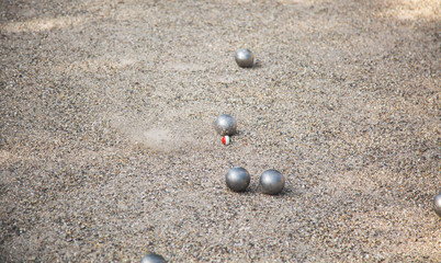 Silver Petanque or Bocce balls on gravel ground with a blur background