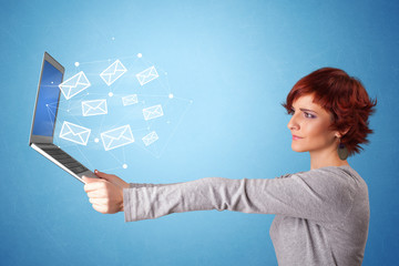 Woman holding laptop with online services symbols