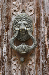 detail of deteriorated wooden doors with Leon doorknobs