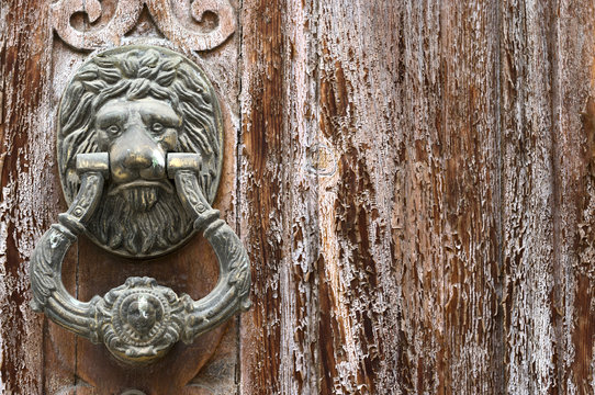 detail of deteriorated wooden doors with Leon doorknobs