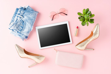 Online shopping concept with empty digital tablet and women's clothes