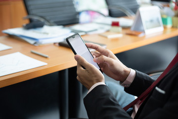 Fototapeta premium businessman hands searching for data on moblie phone with analyzing charts at his workplace.oncept