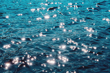 Sun sparkle on deep blue ocean water with water ripple waves