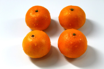 On a light background of a horizontal photo is four Mandarin