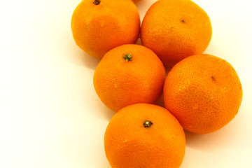 Five tangerines on a white background