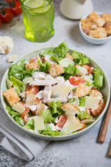 Caesar salad with chicken, Parmesan and wheat croutons on a vintage grey background. Light diet dinner.