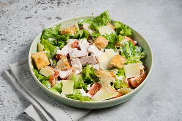 Caesar salad with chicken, Parmesan and wheat croutons on a vintage grey background. Light diet dinner. - obrazy, fototapety, plakaty