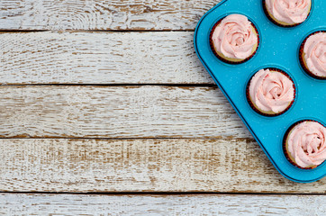 cupcakes on the baking tray on a white wooden table