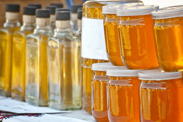 Different types of honey on the table. The colorful jars of honey are sold at the agricultural produce fair.