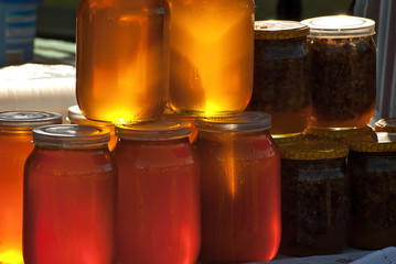 Different types of honey on the table. The colorful jars of honey are sold at the agricultural produce fair.