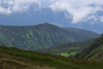 Obraz premium Beautiful green mountains hills and cloudy blue sky