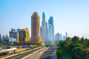 Fototapeta na wymiar Dubai, UAE United Arabs Emirates. Arjaan building and Dubai marina skyscrapers at the background. King Salman Al Saud highway view. Hotels and office buildings of UAE