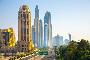 Fototapeta na wymiar Dubai, UAE United Arabs Emirates. Arjaan building and Dubai marina skyscrapers at the background. King Salman Al Saud highway view. Hotels and office buildings of UAE