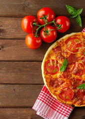 Homemade spicy pizza with sausage and tomato.