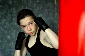 A teenager in a black t-shirt in Boxing training.