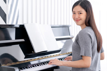 beautiful casual asian woman enjoy practicing piano relax and happiness home background © whyframeshot
