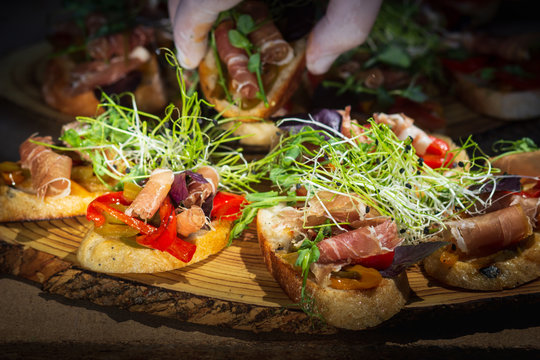 Close up bruschetta with proschuto, tomato, parmesan cheese and arugula