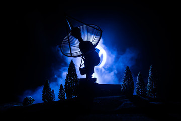Silhouettes of satellite dishes or radio antennas against night sky. Space observatory.