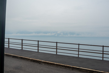 Steel parapet on rural area road in Switzerland on lake and cloudy blue sky background with copy space