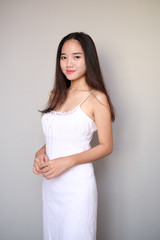 Asian girl with nice outfit, wearing a long plain sleeveless dress.