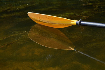 Yellow paddle close up.Yellow paddle over the water.