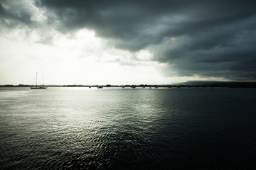 Fototapeta premium Dramatic view of the horizon on a rainy day from the tourist port of Ortigia in Syracuse.