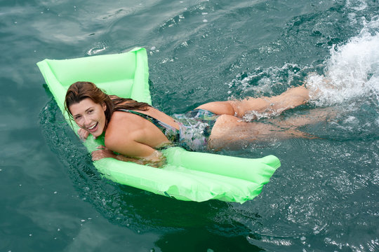ragazza in vacanza al mare su materassino durante navigazione