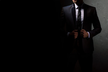 Young handsome successful and confident bearded business man in a suit. Isolated on dark...