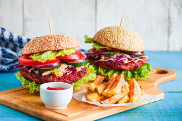two healthy burgers with beetroot patty vegetables frie potato sauce bowl