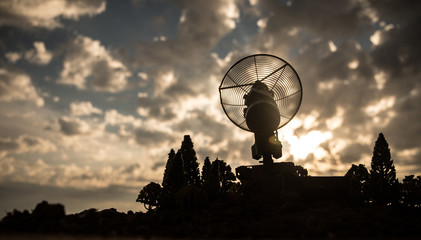 Silhouettes of satellite dishes or radio antennas against sunset sky. Space observatory.