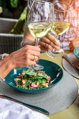 Happy lovers, attractive woman and man enjoy the romance. Attractive couple making selfie, smiling and having fun together. A couple eating salads, drinking wine with taking photos.