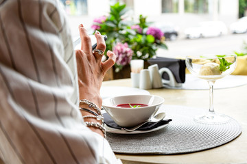 Businesswoman working during the lunch with salad sitting at the vegan restaurant on the beautiful green wall background