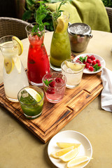 Summer soft drinks, a set of lemonades. Lemonades in jugs on the table, the ingredients of which they are made are arranged around.