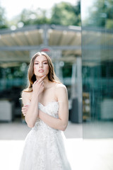 Fototapeta premium Beauty portrait of bride wearing fashion wedding dress with feathers with luxury delight make-up and hairstyle