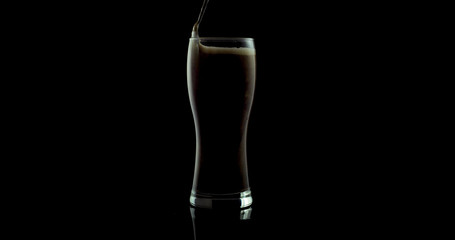 black craft beer in a glass on a black background
