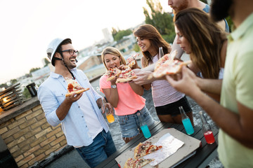 Friends and pizza. Young cheerful people eating pizza and having fun