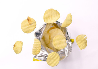 potato chip floating over aluminium foil packaging on white background