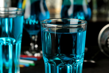 Cocktail blue lagoon in a cocktail glass with lemon and mint on a brown dark table in a bar. bar accessories.