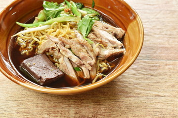 egg noodles with boiled duck in Chinese herb brown soup on bowl