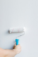 Woman hand holding a paint roller isolated on a white background