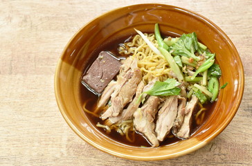 egg noodles with boiled duck in Chinese herb brown soup on bowl